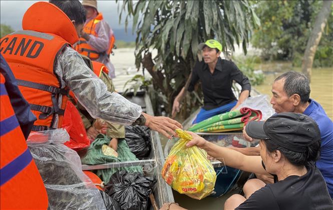 Công an xã Ea Bá, tỉnh Đắk Lắk đến khu vực còn bị ngập lụt cung cấp những gói hàng cứu trợ cho người dân thôn Phú Hữu (xã Hoà Thịnh) còn bị ngập sâu.  Ảnh: Tường Quân - TTXVN