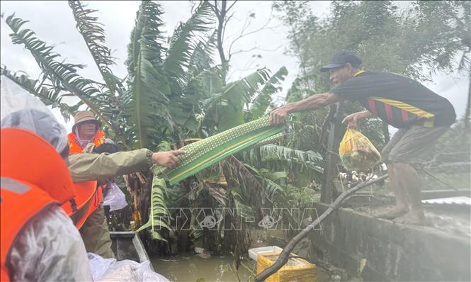 Nhiều người dân vùng lũ nhận hàng cứu trợ từ lực lượng công an.  Ảnh: Tường Quân - TTXVN
