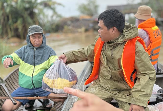 Lực lượng công an trao quần áo đến người dân thôn Phú Hữu (xã Hoà Thịnh).  Ảnh: Tường Quân - TTXVN
