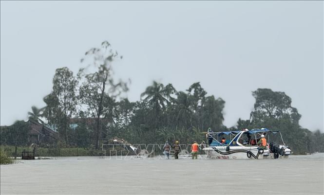 Ca nô tiếp cận người dân vùng lũ cung cấp lương thực, nhu yếu phẩm cho người dân.  Ảnh: Tường Quân - TTXVN
