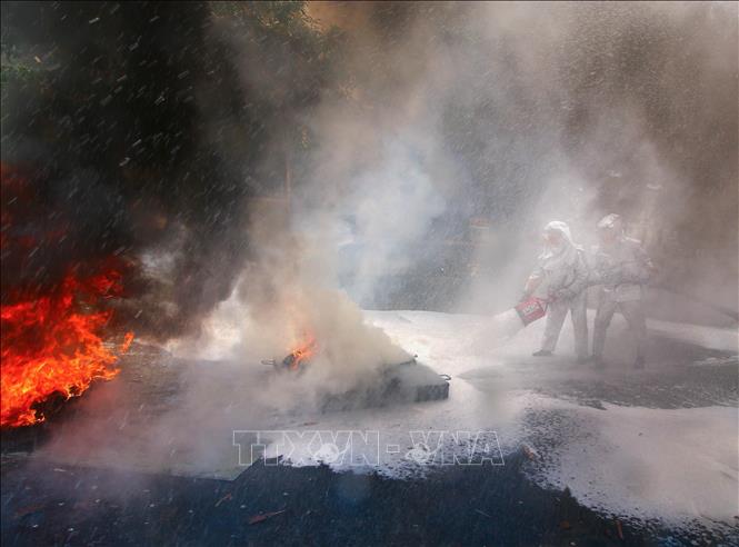 Tình huống dập tắt đám cháy nguy hiểm tại buổi hợp luyện diễn tập phòng thủ. Ảnh: Duy Khương - TTXVN