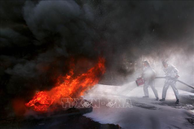 Tình huống dập tắt đám cháy nguy hiểm tại buổi hợp luyện diễn tập phòng thủ. Ảnh: Duy Khương – TTXVN