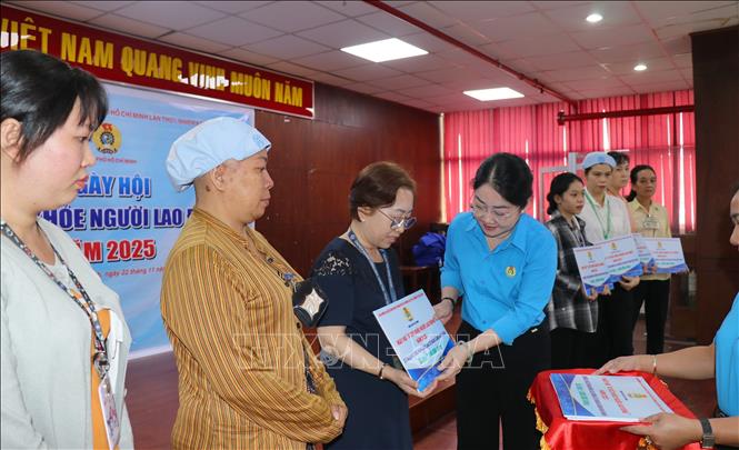 Bà Nguyễn Kim Loan, Phó Chủ tịch Liên đoàn Lao động Thành phố Hồ Chí Minh tặng quà cho công nhân lao động tại ngày hội. Ảnh: Thanh Vũ-TTXVN
