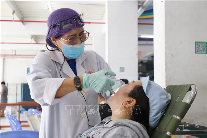 Các y bác sỹ tình nguyện khám và điều trị răng miễn phí cho công nhân lao động tại ngày hội. Ảnh: Thanh Vũ-TTXVN
