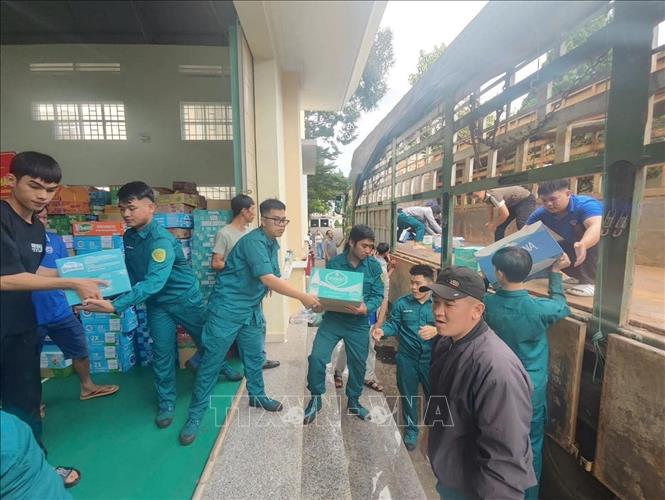 Lực lượng quân đội và nhân dân các xã phía Tây tỉnh Gia Lai sắp xếp hàng hóa gửi về cứu trợ đồng bào lũ lụt. Ảnh: Hồng Điệp - TTXVN
