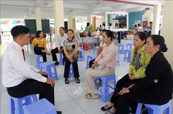 Thầy Đàm Văn Tuyến, Hiệu trưởng Trường THPT Chuyên Trần Văn Giàu gặp gỡ từng nhóm học sinh, phụ huynh để giải đáp thắc mắc. Ảnh: Đức Hạnh - TTXVN
