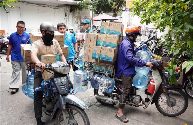 Người dân mang nhu yếu phẩm thiết yếu tới điểm tập kết Nhà văn hóa Thanh Niên ngày 22/11. Ảnh: Trung Tuyến – TTXVN