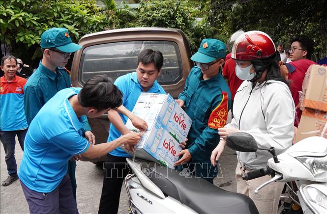 Người dân mang nhu yếu phẩm thiết yếu tới điểm tập kết Nhà văn hóa Thanh Niên. Ảnh: Trung Tuyến – TTXVN