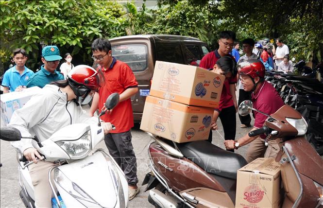 Người dân mang nhu yếu phẩm thiết yếu tới điểm tập kết Nhà văn hóa Thanh Niên. Ảnh: Trung Tuyến – TTXVN