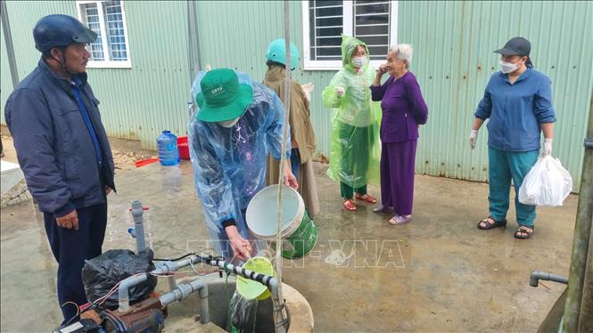Cán bộ y tế Gia Lai thực hiện công tác khử khuẩn hệ thống giếng nước cho người dân nơi vùng lũ. Ảnh: Quang Thái- TTXVN