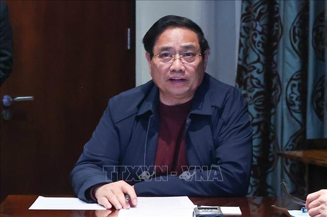 Thủ tướng Phạm Minh Chính chủ trì họp trực tuyến từ Nam Phi, chỉ đạo khắc phục hậu quả mưa lũ. Ảnh: Dương Giang-TTXVN
