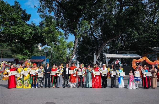 Ban tổ chức trao chứng nhận cho các đoàn nghệ thuật, các đơn vị tham gia chương trình. Ảnh: Hoàng Hiếu - TTXVN