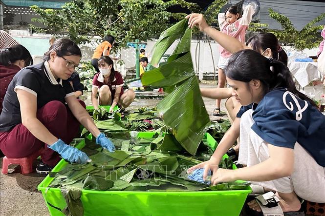 Người dân phường Trảng Dài (tỉnh Đồng Nai) chuẩn bị lá trong đêm để gói bánh chưng, bánh tét gửi ra vùng lũ. Ảnh: Lê Xuân-TTXVN