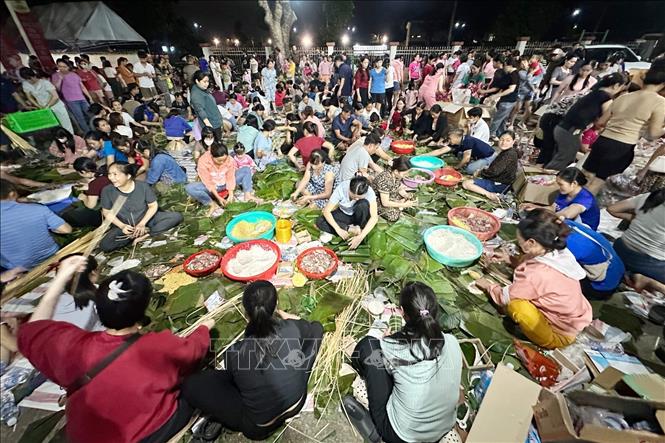 Hàng trăm người dân gói bánh trong đêm tại phường Trảng Dài, tỉnh Đồng Nai để gửi đến bà con vùng lũ. Ảnh: Lê Xuân-TTXVN