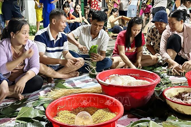 Người dân khắp nơi đổ về nhà văn hóa khu phố 3A, phường Trảng Dài, tỉnh Đồng Nai để gói hàng ngàn bánh chưng, bánh tét gửi đi cứu trợ vùng lũ. Ảnh: Lê Xuân-TTXVN