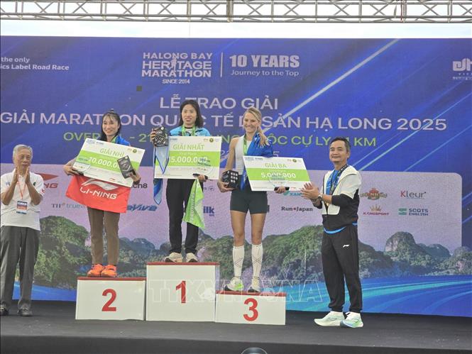 Ban tổ chức trao giải cho các VĐV nữ cự ly 21km.  Ảnh: Thanh Vân-TTXVN 