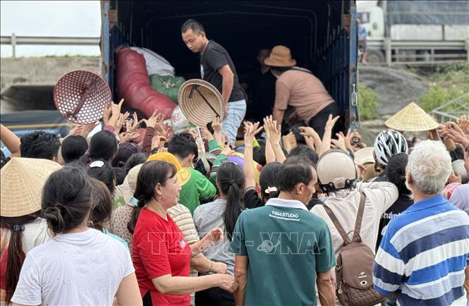 Người dân vùng lũ tỉnh Đắk Lắk nhận hàng cứu trợ. Ảnh: Tường Quân - TTXVN
