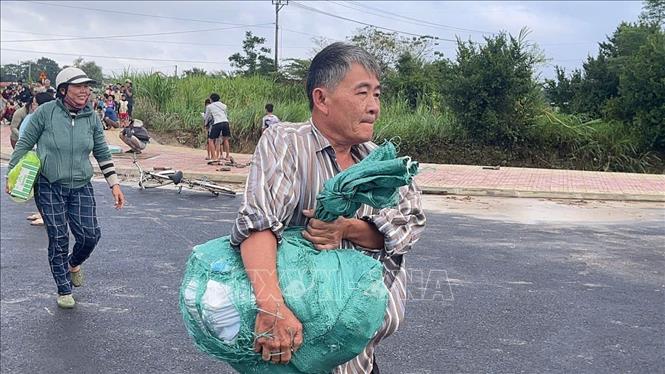 Người dân xã Phong Liên 1 và Phong Liên 2 nhận hàng cứu trợ từ trực thăng của Trung đoàn Không quân 917. Ảnh: TTXVN phát