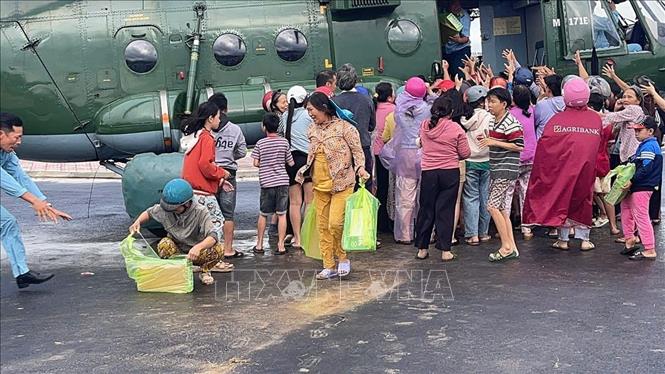 Người dân xã Phong Liên 1 và Phong Liên 2 nhận hàng cứu trợ từ trực thăng của Trung đoàn Không quân 917. Ảnh: TTXVN phát