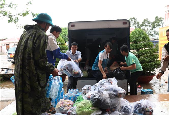 Nhu yếu phẩm thiết yếu được tập kết lên xe để đưa về các khu dân cư bị ngập do lũ. Ảnh: Tuấn Anh – TTXVN