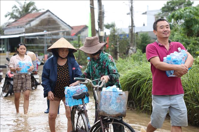 Niềm vui của người dân Đắk Lắk khi nhận nước uống sau nhiều ngày bị mưa lũ vây quanh. Ảnh: Tuấn Anh – TTXVN
