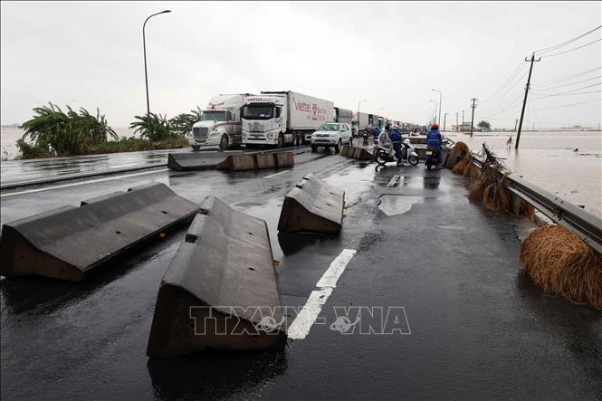  Nỗ lực khắc phục giải phân cách cứng bị trôi dạt trên Quốc lộ 1A. Ảnh: Đỗ Trưởng - TTXVN