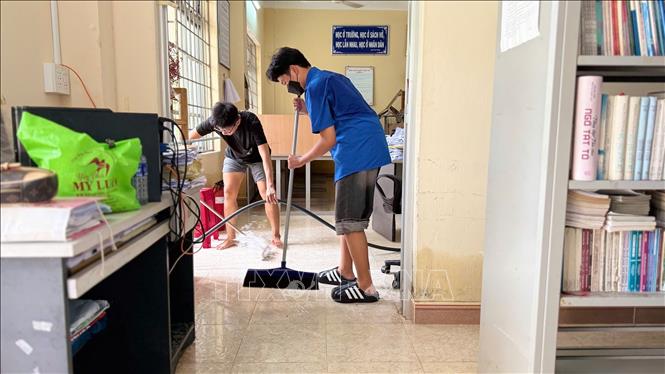 Giáo viên Trường THPT Nguyễn Trãi, phường Tuy Hòa, tỉnh Đắk Lắk khẩn trương dọn dẹp vệ sinh trường lớp sau lũ. Ảnh: Nguyên Dung - TTXVN