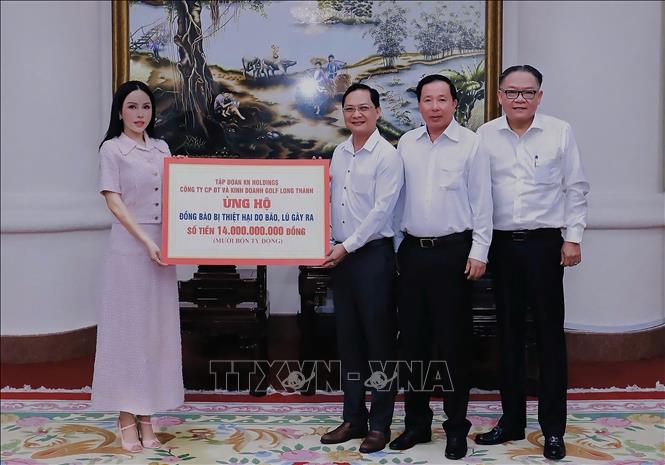 Bà Lê Nữ Thùy Dương, Chủ tịch kiêm Tổng giám đốc Tập đoàn KN Holdings đã trao bảng tượng trưng, thông qua tỉnh Đồng Nai ủng hộ đồng bào bị thiệt hại do bão, lũ gây ra. Ảnh: Lê Xuân-TTXVN