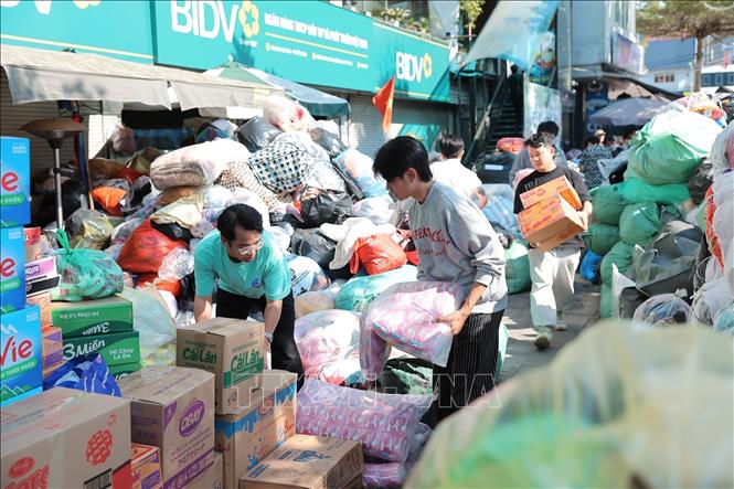 Tình nguyện viên đóng gói nhu yếu phẩm để gửi tới đồng bào miền Trung tại điểm Ô Chợ Dừa. Ảnh: Lê Đông - TTXVN