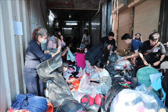 Tình nguyện viên phân loại và đóng gói quần áo để gửi tới đồng bào miền Trung tại điểm Ô Chợ Dừa. Ảnh: Lê Đông - TTXVN