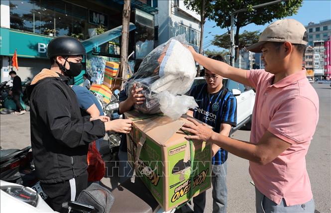 Tình nguyện viên tiếp nhận hỗ trợ của người dân Thủ đô dành cho miền Trung tại điểm Ô Chợ Dừa. Ảnh: Lê Đông - TTXVN