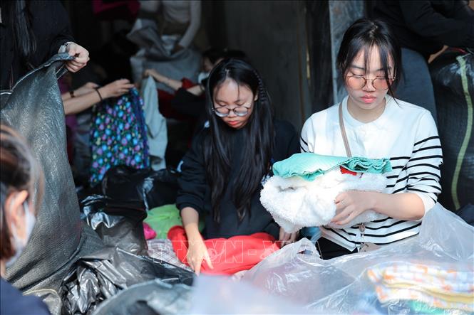 Tình nguyện viên đóng gói nhu yếu phẩm để gửi tới đồng bào miền Trung tại điểm Ô Chợ Dừa. Ảnh: Lê Đông - TTXVN