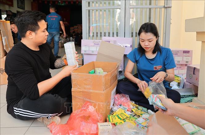Tình nguyện viên đóng gói nhu yếu phẩm để gửi tới đồng bào miền Trung tại điểm 105 Xuân La. Ảnh: Lê Đông - TTXVN