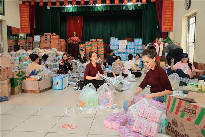 Tình nguyện viên đóng gói nhu yếu phẩm để gửi tới đồng bào miền Trung tại điểm 105 Xuân La. Ảnh: Lê Đông - TTXVN