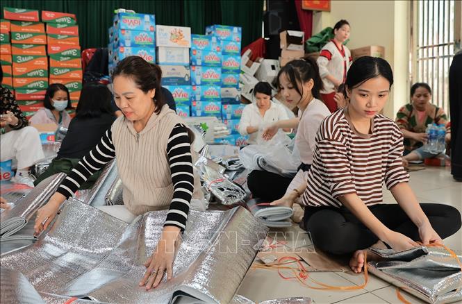 Tình nguyện viên đóng gói nhu yếu phẩm để gửi tới đồng bào miền Trung tại điểm 105 Xuân La. Ảnh: Lê Đông - TTXVN