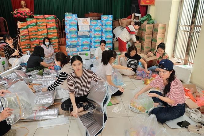 Tình nguyện viên đóng gói nhu yếu phẩm để gửi tới đồng bào miền Trung tại điểm 105 Xuân La. Ảnh: Lê Đông - TTXVN