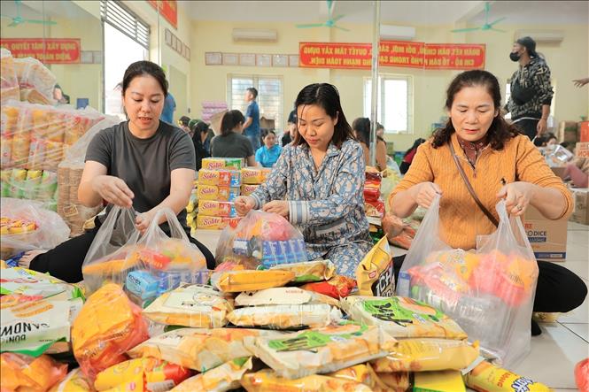 Tình nguyện viên đóng gói nhu yếu phẩm để gửi tới đồng bào miền Trung tại điểm 105 Xuân La. Ảnh: Lê Đông - TTXVN