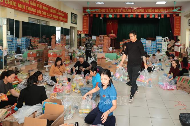 Tình nguyện viên đóng gói nhu yếu phẩm để gửi tới đồng bào miền Trung tại điểm 105 Xuân La. Ảnh: Lê Đông - TTXVN