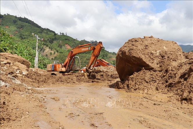 Công nhân dùng máy múc dọn dẹp đất đá sạt lở từ sườn núi tràn xuống tuyến tỉnh lộ ĐT 707, đoạn qua thôn Bậc Rây 1 (xã Bác Ái Tây, Khánh Hòa). Ảnh: Nguyễn Thành – TTXVN