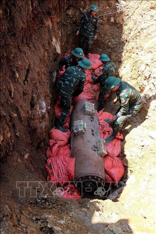 Công tác đặt mìn, chèn tải cát, đất hủy nổ bom M118 hoàn tất. Ảnh: Thanh Hải - TTXVN 