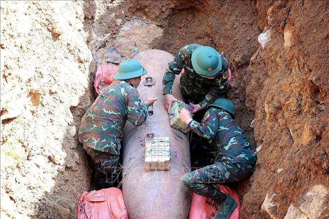 Lực lượng quân đội hoàn tất việc cài đặt mìn kích nổ bom M118. Ảnh: Thanh Hải - TTXVN 