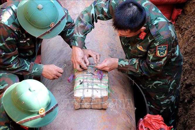 Công tác cài mìn kích nổ bom M118 hết sức tỉ mỉ và tuyệt đối an toàn. Ảnh: Thanh Hải - TTXVN 