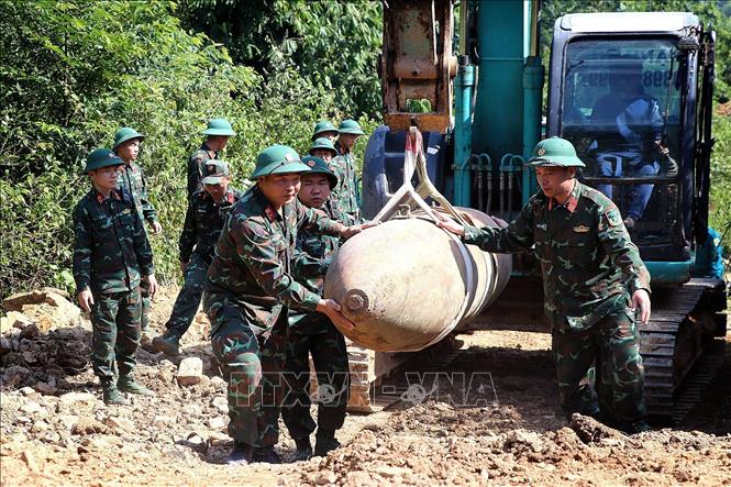 Lực lượng quân đội vận chuyển bom M118 trên đoạn đường dốc. Ảnh: Thanh Hải - TTXVN 