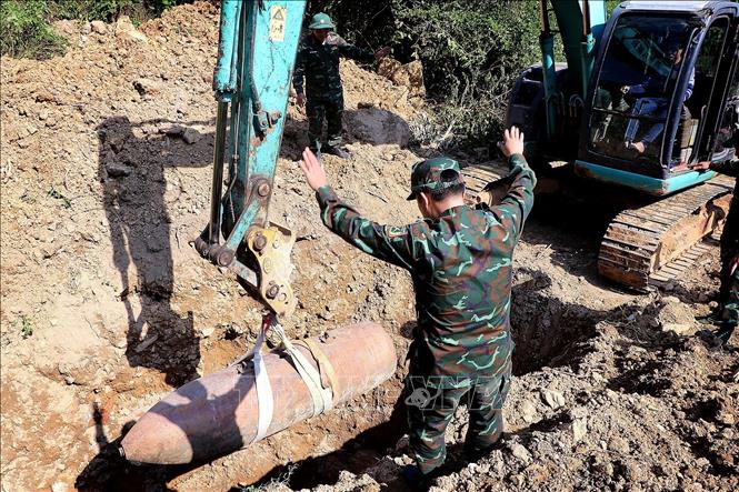 Bom M118 được hạ xuống hố hủy nổ. Ảnh: Thanh Hải - TTXVN 