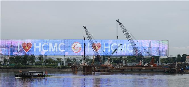 Công trình cầu đi bộ qua sông Sài Gòn đang được xây dựng, dự kiến hoàn thành trong năm 2026 được kỳ vọng tăng tính liên kết hạ tầng giữa khu tài chính hiện hữu và Khu đô thị Thủ Thiêm. Ảnh: Hứa Chung-TTXVN