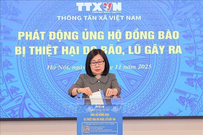 Deputy General Director of the Vietnam News Agency Doan Thi Tuyet Nhung donates at the fundraising campaign. VNA Photo: Hoàng Hiếu