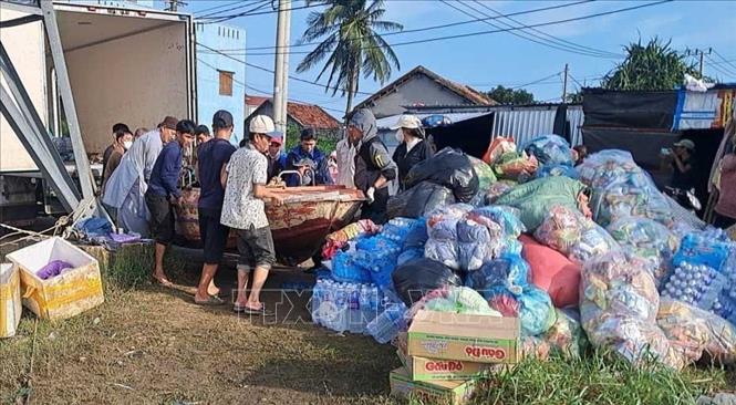 Các đoàn thiện nguyện dùng xuồng máy đi từ bến đò Phú Lạc để vào thôn Phước Giang. Ảnh: Phạm Kha - TTXVN