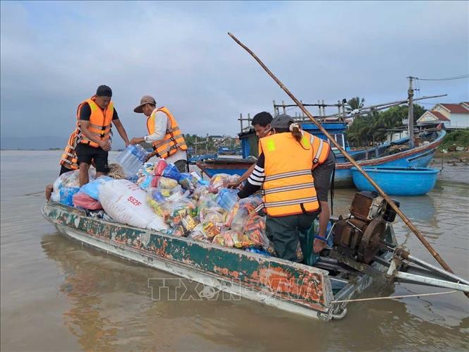 Các đoàn thiện nguyện dùng xuồng máy đi từ bến đò Phú Lạc để vào thôn Phước Giang. Ảnh: Phạm Kha - TTXVN
