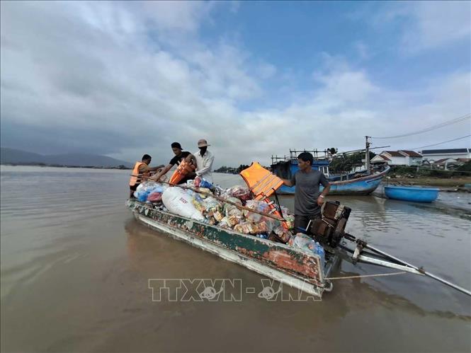 Các đoàn thiện nguyện dùng xuồng máy đi từ bến đò Phú Lạc để vào thôn Phước Giang. Ảnh: Phạm Kha - TTXVN