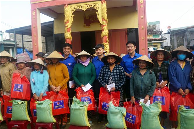 Đoàn công tác tặng túi an sinh cho người dân xã Tuy Phước Đông. Ảnh: Trịnh Bang Nhiệm - TTXVN